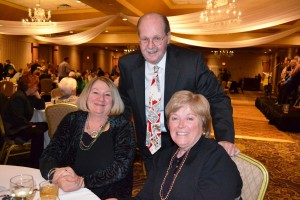 (From l-r) Dee Hennemuth celebrates with UNC board members Atty. Drew Hailstone and Elizabeth Burns at United Neighborhood Centers’ 14th Annual Mardi Gras Celebration.