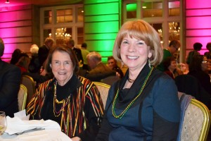 UNC board member Jane Oppenheim (left) Dede Tersteeg got into the spirit of Mardi Gras with beads and New Orleans style food.